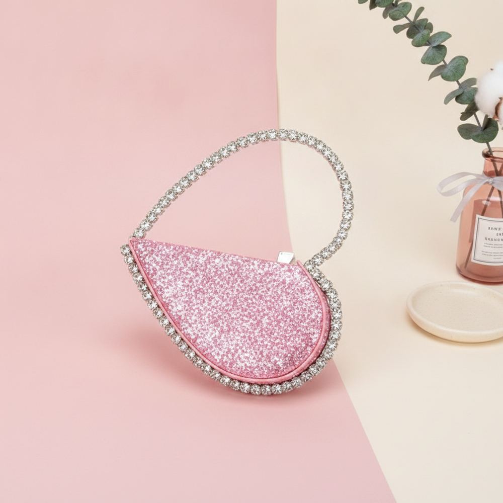 A diamond-studded dinner bag with a diamond heart-shaped clutch centered on a soft gradient background of rose, bright white,